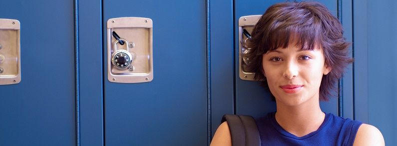 Girl standing in front of lockers with backpack